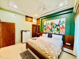 a bedroom with a bed with a painting on the wall at Hotel Maheshwar's Stay in Maheshwar