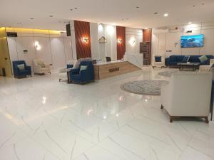 een lobby met een wachtkamer met stoelen en tafels bij فيلمست ريزيدنس ابهاVelmist Residence Abha in Abha