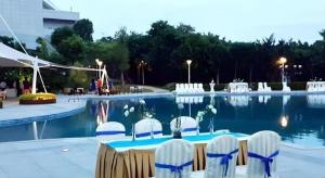 a table and chairs in front of a swimming pool at Quanzhou Guest House Hotel in Quanzhou