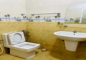 a bathroom with a white toilet and a sink at Aadhira Guest House in Trincomalee +15 photos