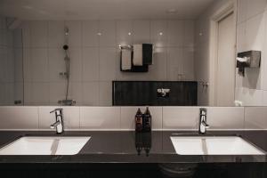 a bathroom with two sinks and a large mirror at Home Hotel Grand Helsingborg in Helsingborg +52 photos