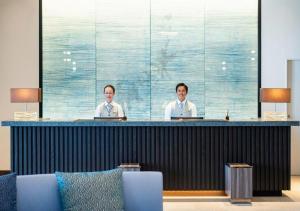 two men sitting at a bar in a room at Goto Tsubaki Hotel in Hukue
