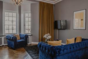 un salon avec un canapé bleu et deux chaises dans l'établissement Home Hotel Grand Helsingborg, à Helsingborg