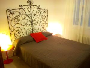 Una cama con una almohada roja en un dormitorio en Bnap Masip, en Oviedo