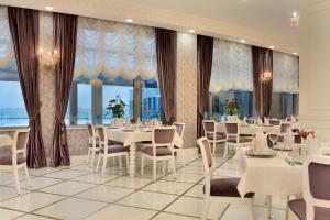 a restaurant with tables and chairs and large windows at Ramada by Wyndham Baku in Baku +101 photos