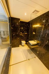 a bathroom with two toilets and a glass wall at Aarambh By The Sky Imperial Indore in Indore