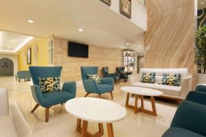 ドバイにあるRamada by Wyndham Downtown Dubaiの青い椅子とソファ、テーブルが備わる待合室