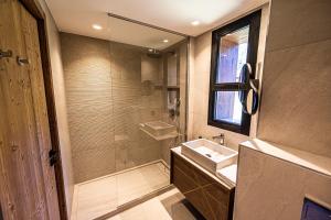 a bathroom with a sink and a glass shower at Appartement de luxe les Arcs 4 chambres skis aux pieds in Arc 1800 +43 photos