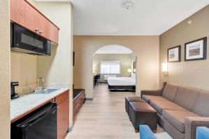 a hotel room with a couch and a bed at Comfort Suites Lakewood - Denver in Lakewood