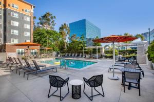 a patio with tables and chairs and a pool at Cambria Hotel LAX in El Segundo