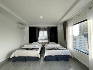 Dos camas en una habitación con una gran ventana. en Jason Residencia One Hotel, en Phnom Penh 31 fotos más