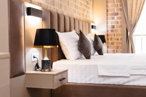 - une chambre avec un lit et une lampe sur une table de chevet dans l'établissement Air Hotel, à Tachkent