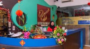 a woman standing behind a counter in a store at Super OYO 1114 Neo Pegasus Hotel in Segamat