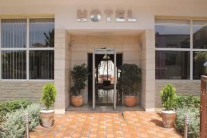 a hotel with potted plants in front of a door at Hotel Cafe Verdi in El Jadida