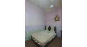 a small bedroom with a bed in a room at Hotel O Penginapan Almera in Inanam