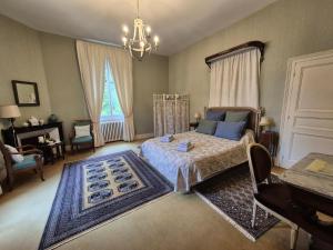 a bedroom with a bed and a table and a window at Le manoir d'Estiveaux in Le Châtelet