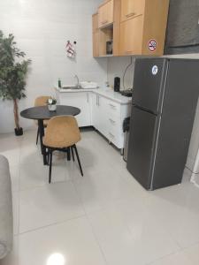 a kitchen with a black refrigerator and a table at Roots Self Catering Budget Unit 2-Budget Room in Port Elizabeth