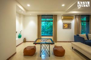 un salon avec une table de ping-pong dans l'établissement StayVista at Petals Of Dusk - Outdoor pool, WiFi & BBQ, à Jaipur
