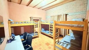 a dorm room with two bunk beds and a desk at Sun Hostel and Restaurant Kampot in Kampot