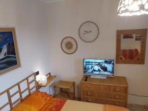 ein Schlafzimmer mit einem Bett und einem Fernseher auf einer Kommode in der Unterkunft Relais Frantoio delle Pietre in Conversano