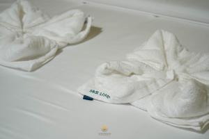a pair of white towels sitting on a bed at Sun Hostel and Restaurant Kampot in Kampot +52 photos