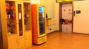 a yellow refrigerator in a room with shelves at 7 Days Inn Guangzhou Huangpu East Zone Times Plaza in Guangzhou