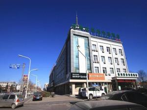 a large white building on a city street with cars at GreenTree Inn Langfang Sanhe South Yingbin Road Express Hotel in Sanhe