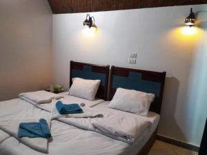 two twin beds in a room with towels on them at Nubian Spirit in Aswân Reservoir Colony