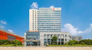 a tall white building with a red clock on it at GreenTree Eastern Yancheng Administration Center Hotel in Yancheng