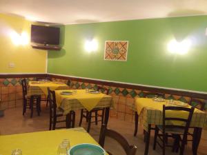 een restaurant met gele tafels en een groene muur bij Hotel Sant'Anna in Floresta
