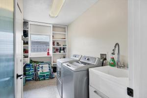 a laundry room with a washing machine and a sink at Charming 3BR Retreat Near Sarasota Beaches in Sarasota +22 photos