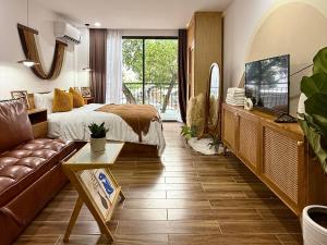 a bedroom with a bed and a couch and a tv at The Little Danang in Da Nang