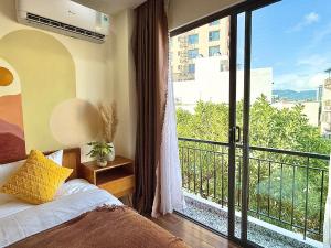a bedroom with a bed and a balcony with a view at The Little Danang in Da Nang +149 photos