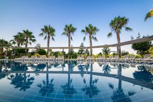 a swimming pool with chairs and palm trees at Vita Silva Hotel in Kızılot +44 photos