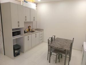 een keuken met een tafel en een tafel met stoelen bij فيلمست ريزيدنس ابهاVelmist Residence Abha in Abha