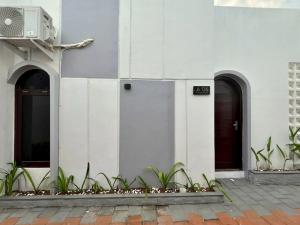 a white building with two doors and some plants at Prama Peaceful Living Villa in Ngaglik