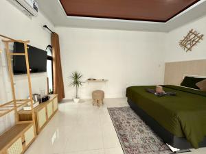 a bedroom with a bed and a tv in it at Prama Peaceful Living Villa in Ngaglik +17 photos