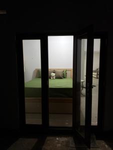 a view of a bed through a glass door at Sri Vishwa Buddha MUni in Kalagedihena