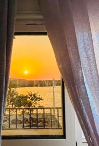 a window with a view of the ocean and the sunset at Golden Sun House II in Abu Simbel