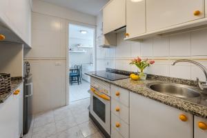 a kitchen with white cabinets and a sink at Eva The View in Puerto de Santiago