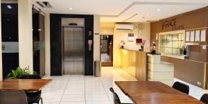 een restaurant met 2 tafels en een aanrecht en een keuken bij Grace Setia Hotel in Surabaya