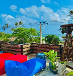 a patio with blue and red cushions and the ocean at The Lotus House - Ahangama in Ahangama