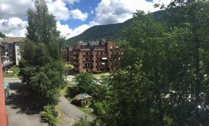 a view of a building with trees and a mountain at Appartamento Aprica 2.0 in Aprica