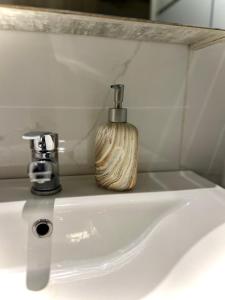 a bathroom sink with a soap dispenser on top of it at Fillio 's Apartment, Ptolemaida in Ptolemaida +7 photos