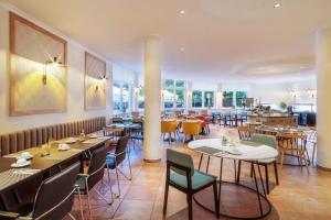 a dining room with tables and chairs in a restaurant at Hotel Bochum Wattenscheid affiliated by Meliá in Bochum
