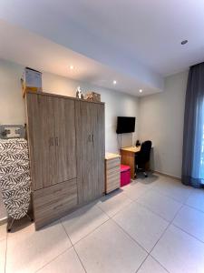 a large wooden cabinet in a room with a desk at Fillio 's Apartment, Ptolemaida in Ptolemaida