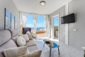 a living room with a couch and a tv at Eva The View in Puerto de Santiago