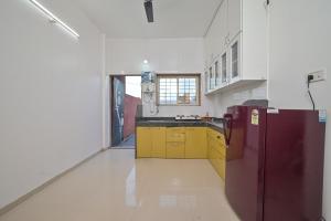 a kitchen with yellow cabinets and a purple refrigerator at ll EMPYREAN STAY ll 2BHK ll LUCIFER VILLA ll AC ll PRIVATE POOL ll in Lonavala