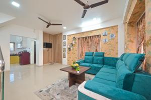 a living room with a blue couch and a table at ll EMPYREAN STAY ll 2BHK ll LUCIFER VILLA ll AC ll PRIVATE POOL ll in Lonavala