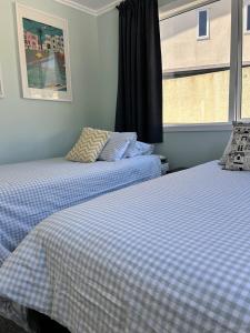 two beds sitting next to a window in a room at Bay Vista - glorious Golden Bay Ocean Views in Pohara